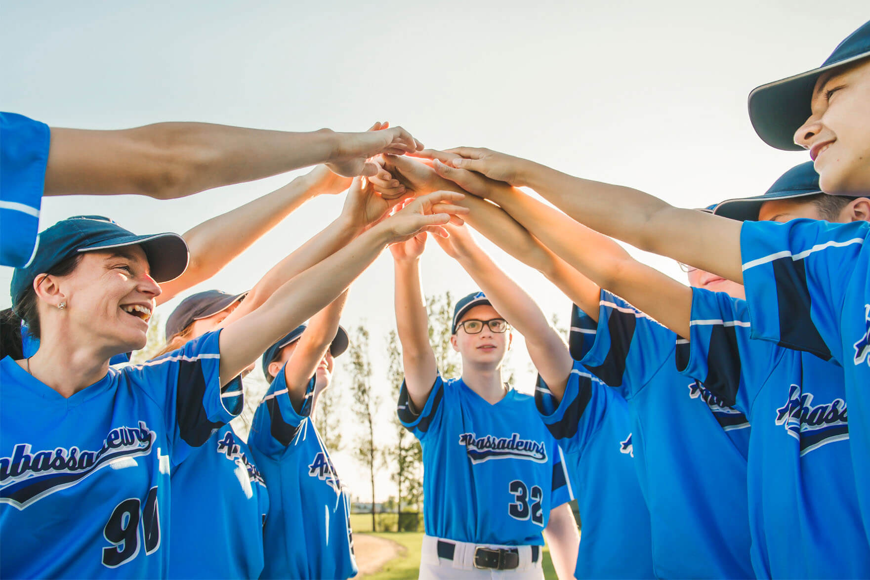 Youth baseball team stands in a huddle together